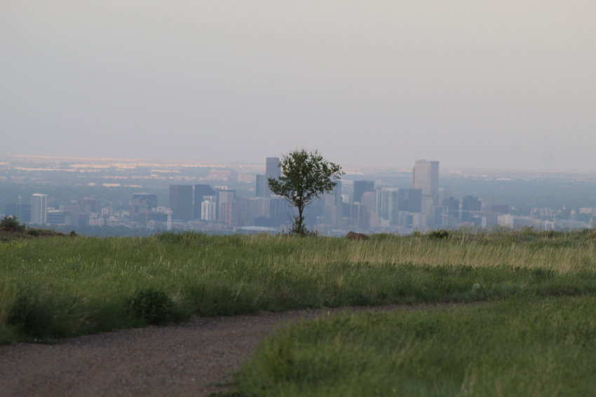 As seen from South Table Mountain, the sun sets on downtown Denver on June 16.
